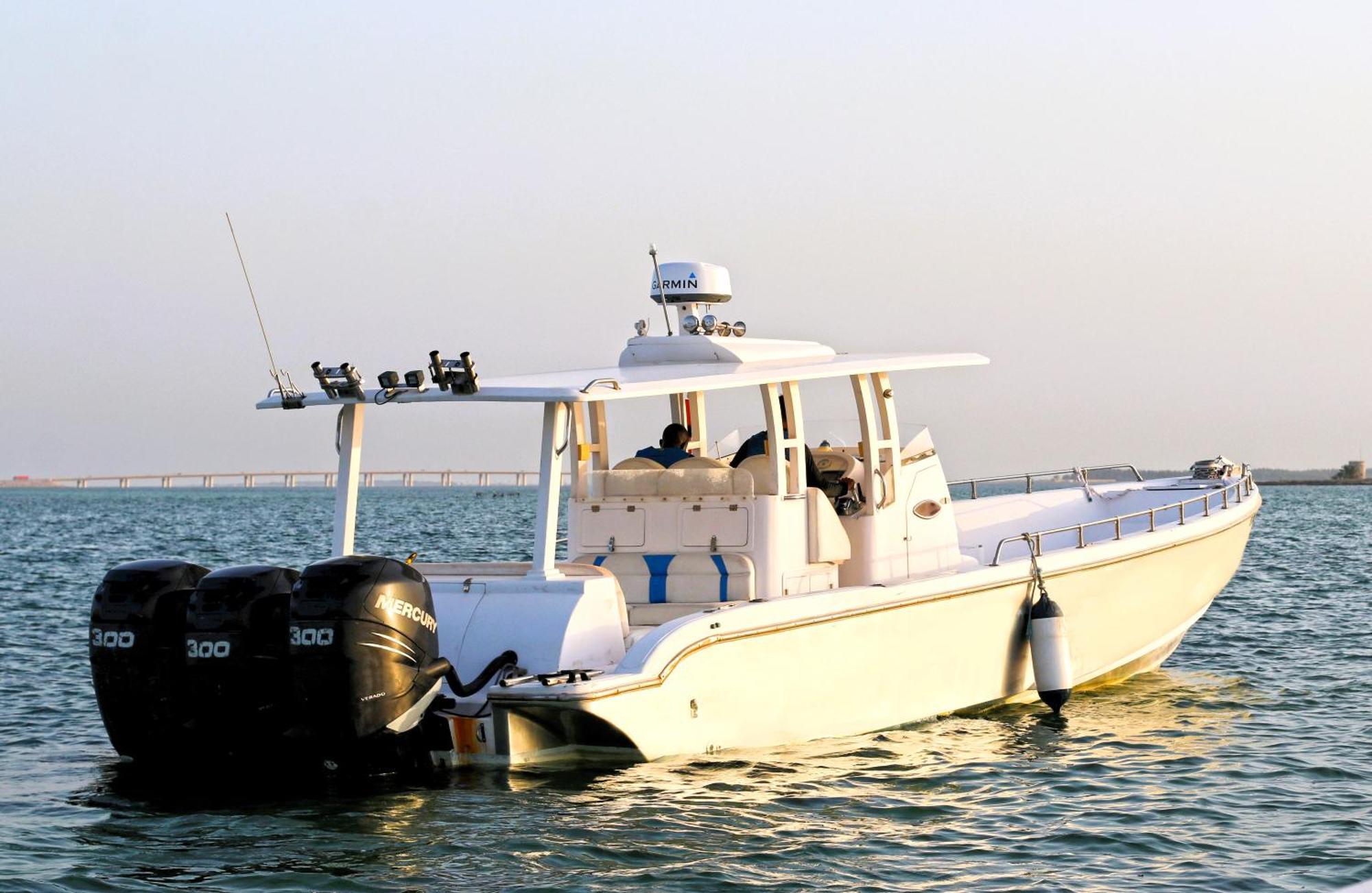 Lagoona Beach Luxury Resort And Spa Μανάμα Εξωτερικό φωτογραφία The photo shows a large, white motorboat equipped with three powerful outboard engines at the stern. The boat has a sleek design, with a spacious open deck and a covered cabin area that likely provides shelter and controls for navigation. The scene i