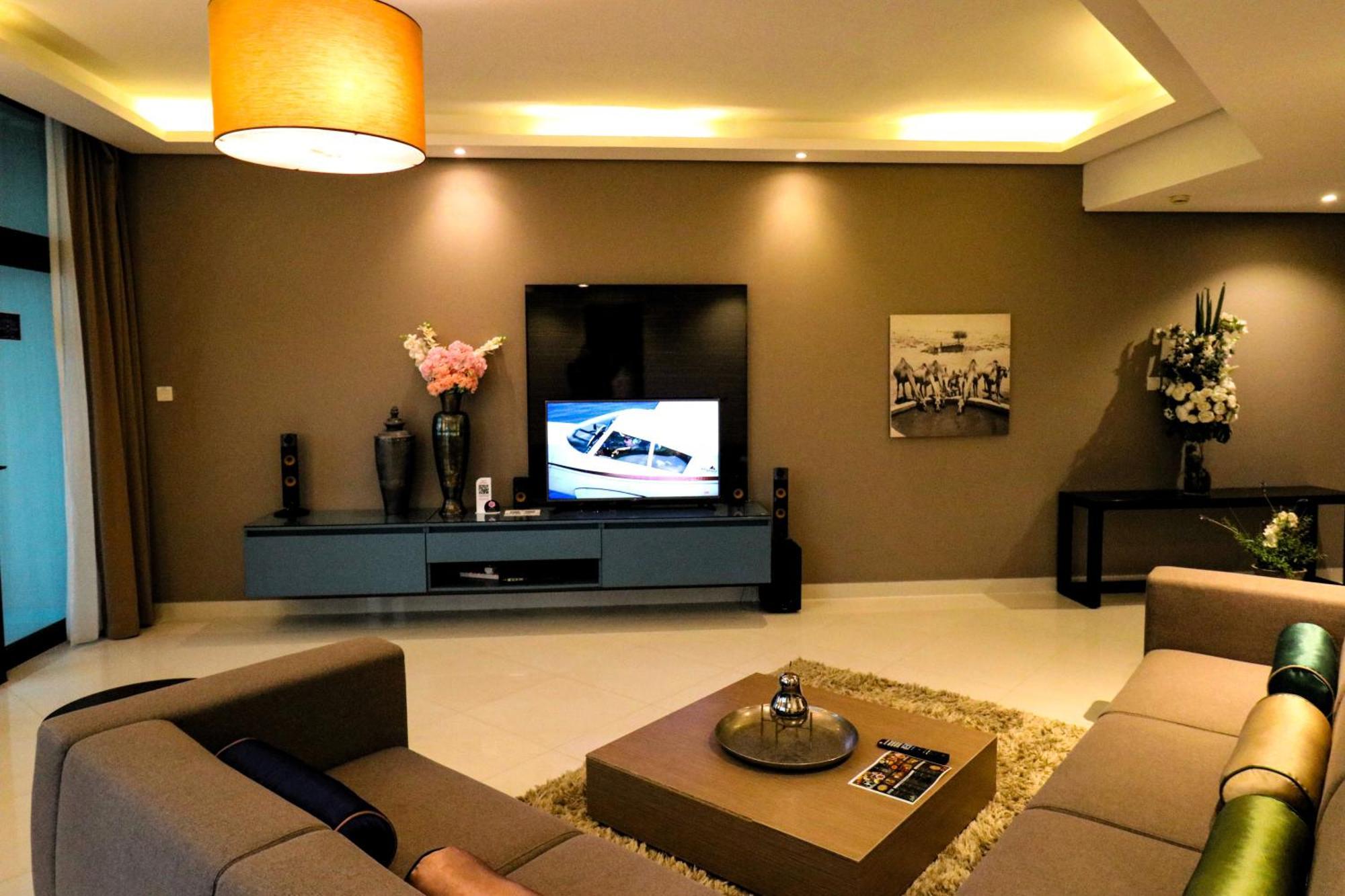 Lagoona Beach Luxury Resort And Spa Μανάμα Εξωτερικό φωτογραφία The photo shows a modern living room with a neutral color palette. Key features include:

- A comfortable seating area with a sofa arranged around a coffee table.
- A minimalist coffee table with a decorative item on top.
- A large flat-screen televi